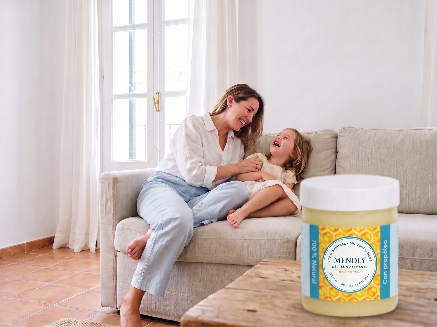 Mère et fille riant sur le canapé avec un pot de Mendly